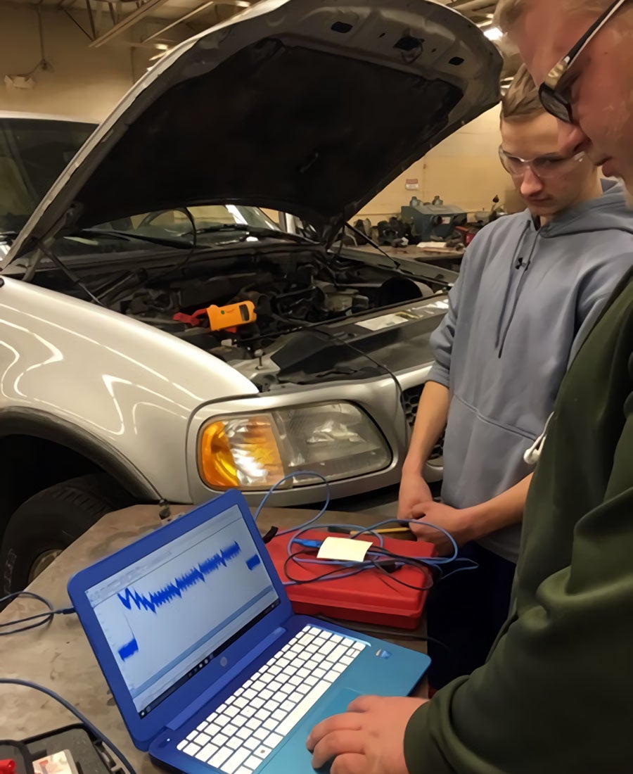 Warren-Alvarado-Oslo students working on donated vehicle by C&M
